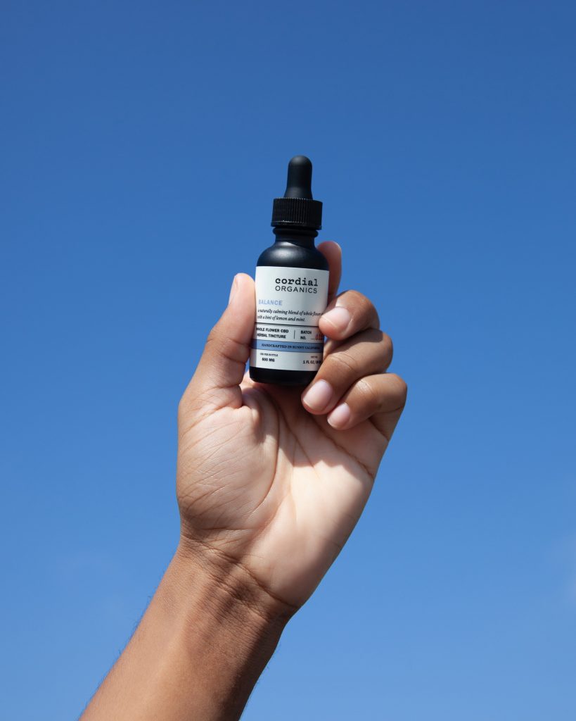 one ounce bottle of cbd balance lifted to the sky